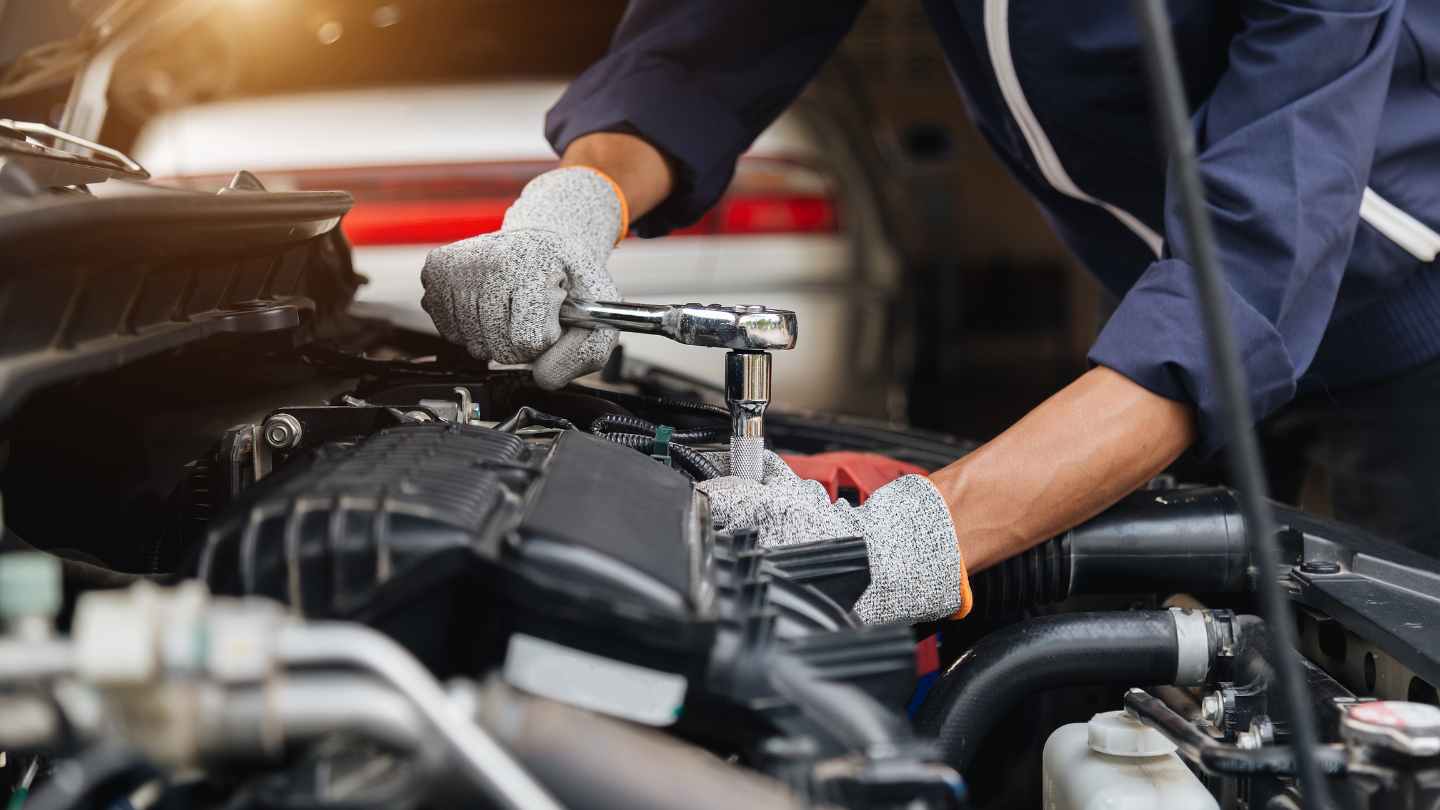 Technician using a socket wrench under the hood